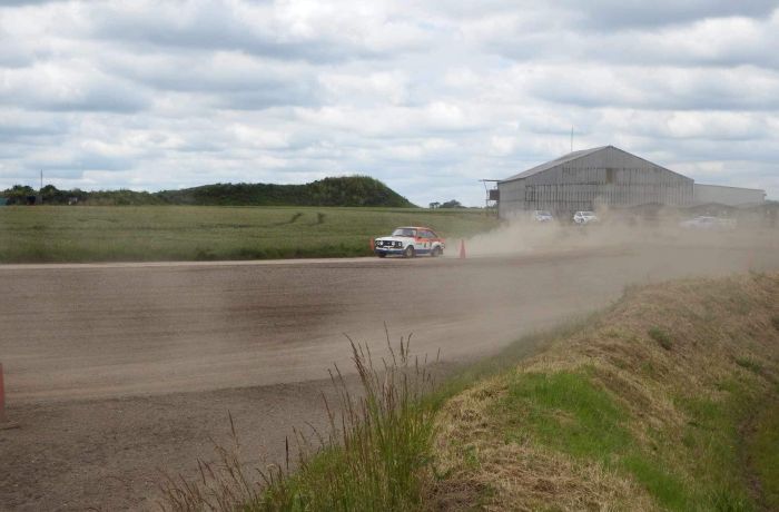 a rally car being driven along a gravel track on a rally driving experience day