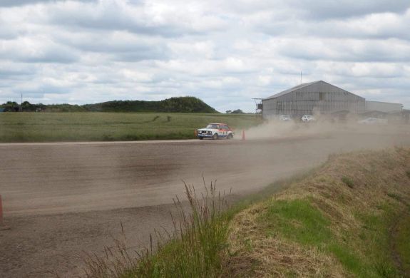 a rally car being driven along a gravel track on a rally driving experience day