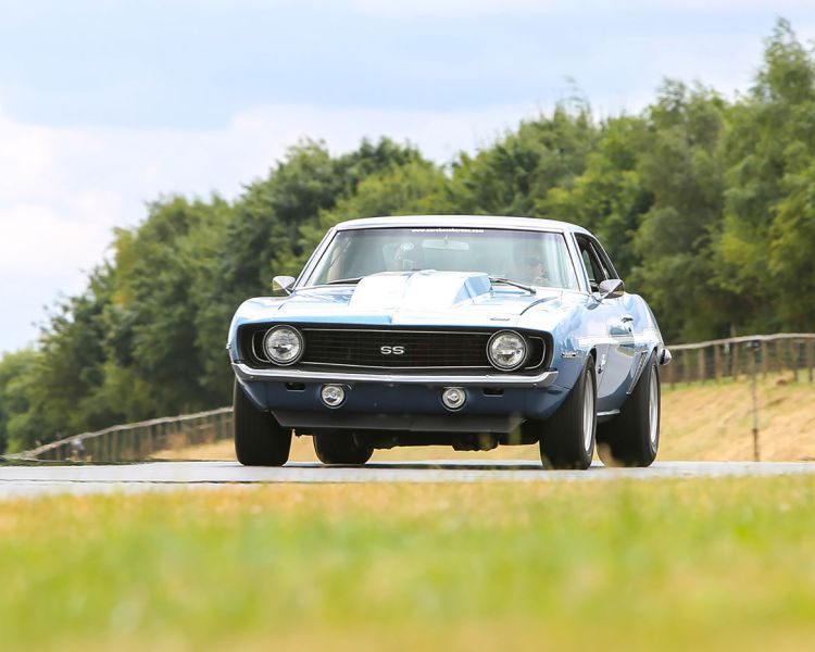 a vintage camaro on a track for a driving experience day