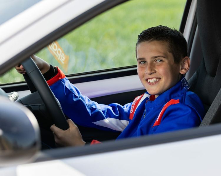 a young boy behind the wheel of a car on a junior driving experience day