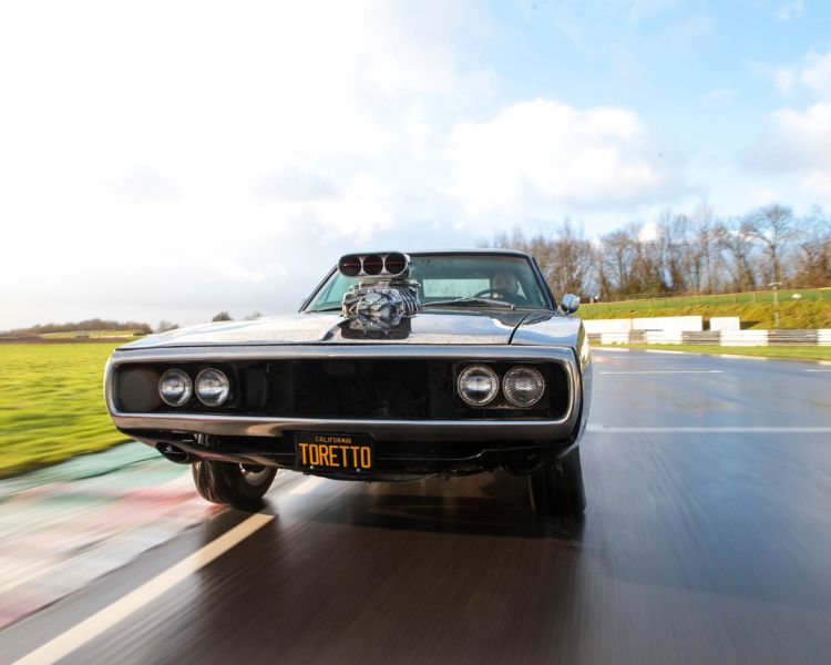 replica of dom's charger from the fast and the furious film on a race track for a movie cars driving experience day