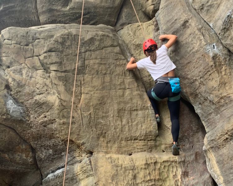 Low view  of a woman climbing at Intro to Climbing Hatt Adventures