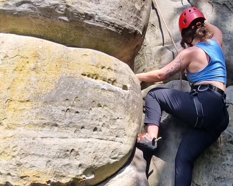 A woman mid climb at Intro to Climbing Hatt Adventures