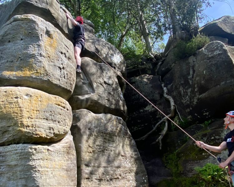A man climbing with a grounded supporter at Intro to Climbing Hatt Adventures