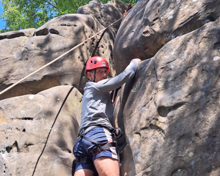 A man near the top of rocks at Intro to Climbing Hatt Adventures