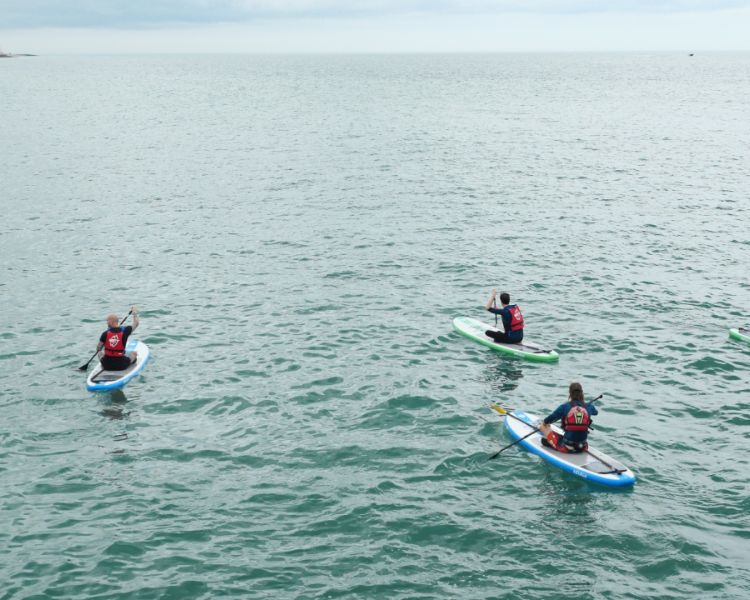 A group of 5 paddle boarding at SUP Hatt Adventures