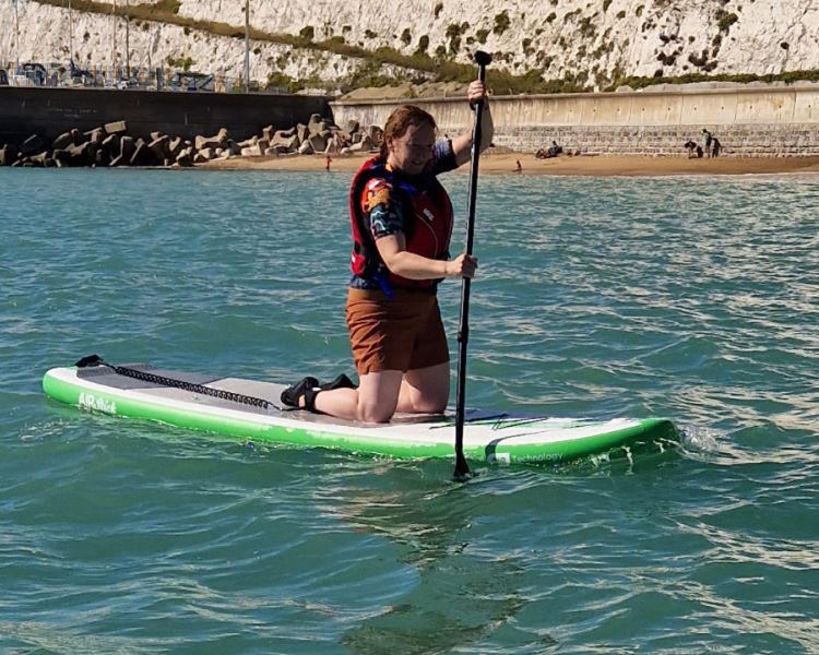 A sunny view of a solo woman paddle boarding at SUP Hatt Adventures