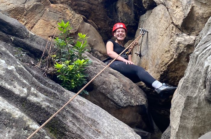 A low view of a woman sat on rocks at Climbing Exp Hatt Adventures