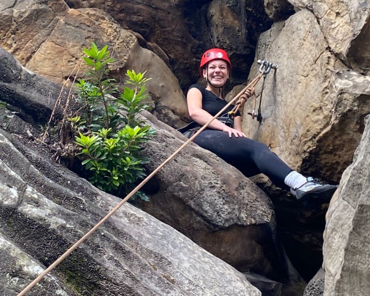 A low view of a woman sat on rocks at Climbing Exp Hatt Adventures
