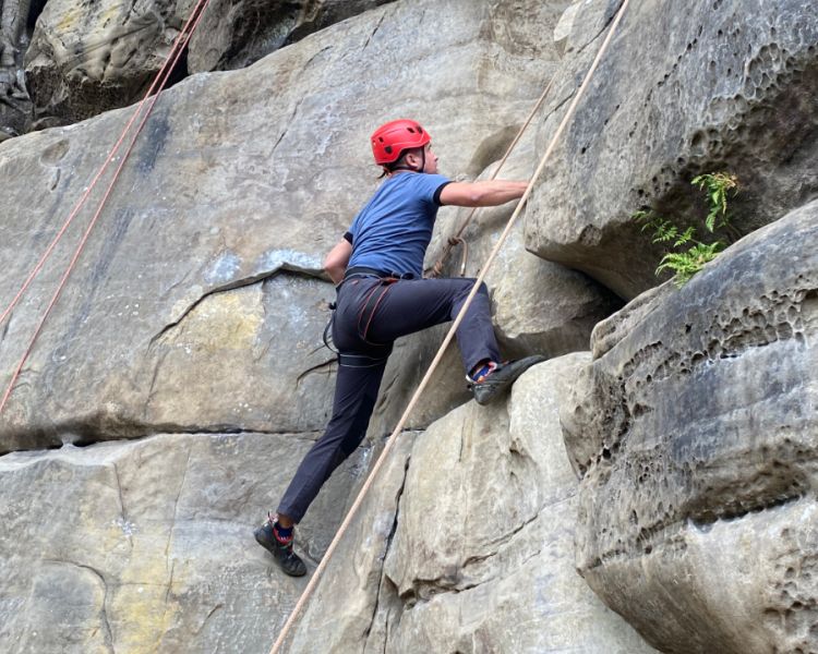 A man climbing up a rock face at  Climbing Exp Hatt Adventures