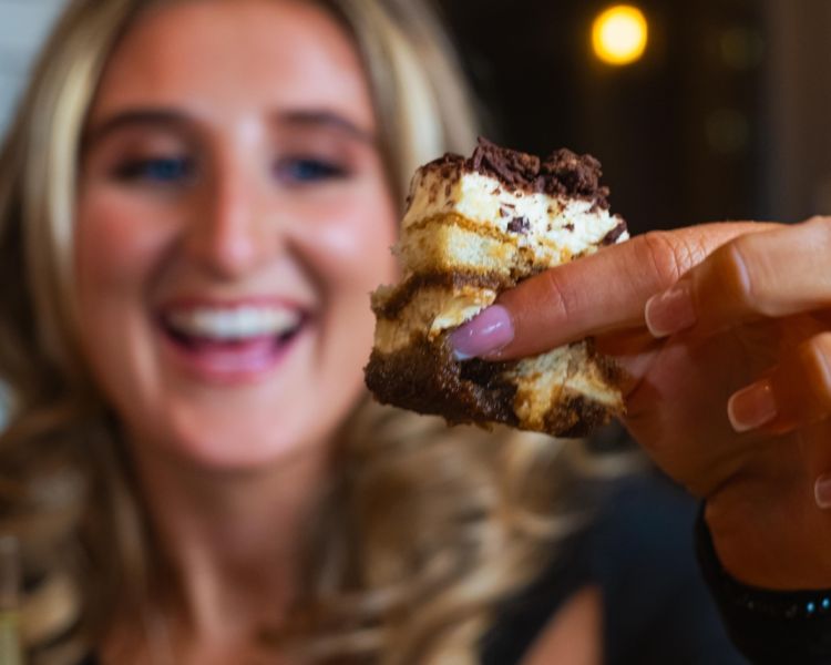A close up of a woman holding cake