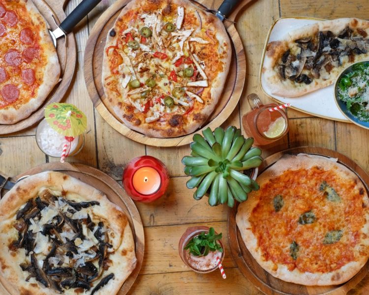 an assortment of pizzas on the table
