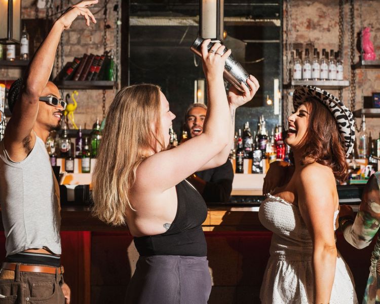 2 ladies at a bar shaking cocktails 2