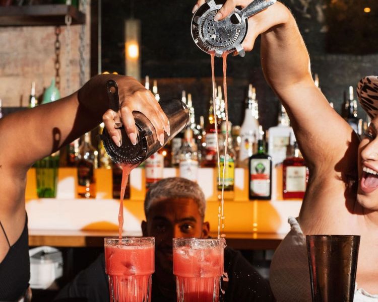 2 female bartenders pouring cocktails