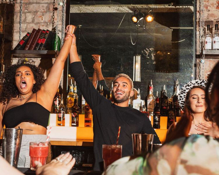 bartenders with their arms up like they're celebrating