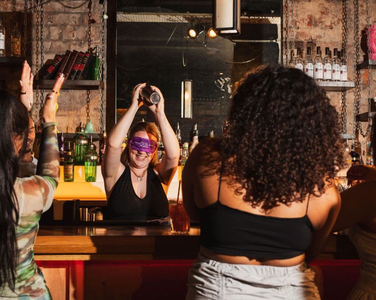 a bartender shaking a drink while blindfolded