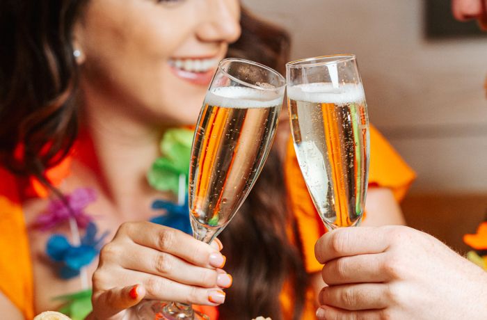 a woman and man with glasses of prosecco at a cuban inspired afternoon tea
