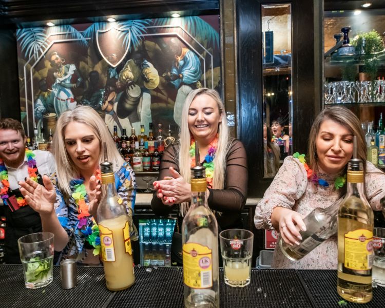three ladies mixing cocktails on a cocktail masterclass at revolucion de cuba