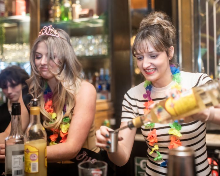 two ladies mixing cocktails on a cocktail masterclass at revolucion de cuba