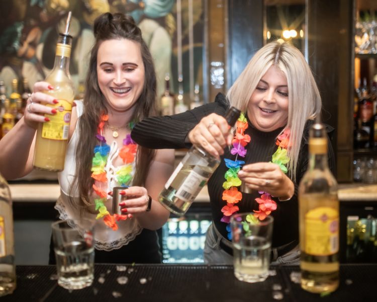 two ladies behind the bar mixing cocktails on a cocktail masterclass at revolucion de cuba