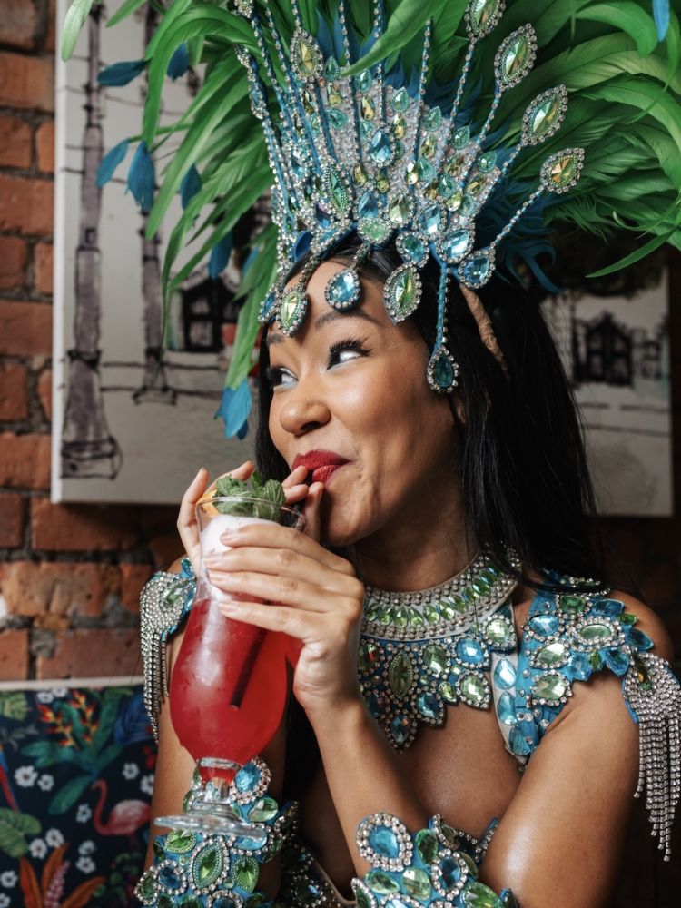 a lady dressed in rio carnival dress enjoying a cocktail on a tapas and cocktails experience at revolucion de cuba
