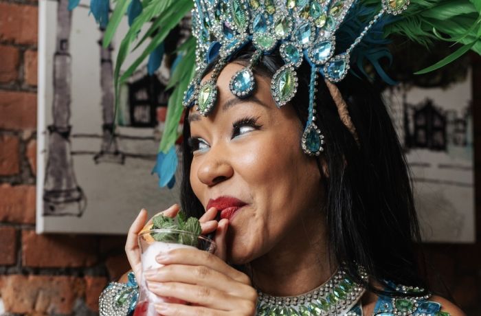 a lady dressed in rio carnival dress enjoying a cocktail on a tapas and cocktails experience at revolucion de cuba