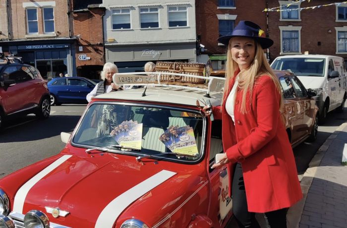 a woman standing next to a classic red mini cooper