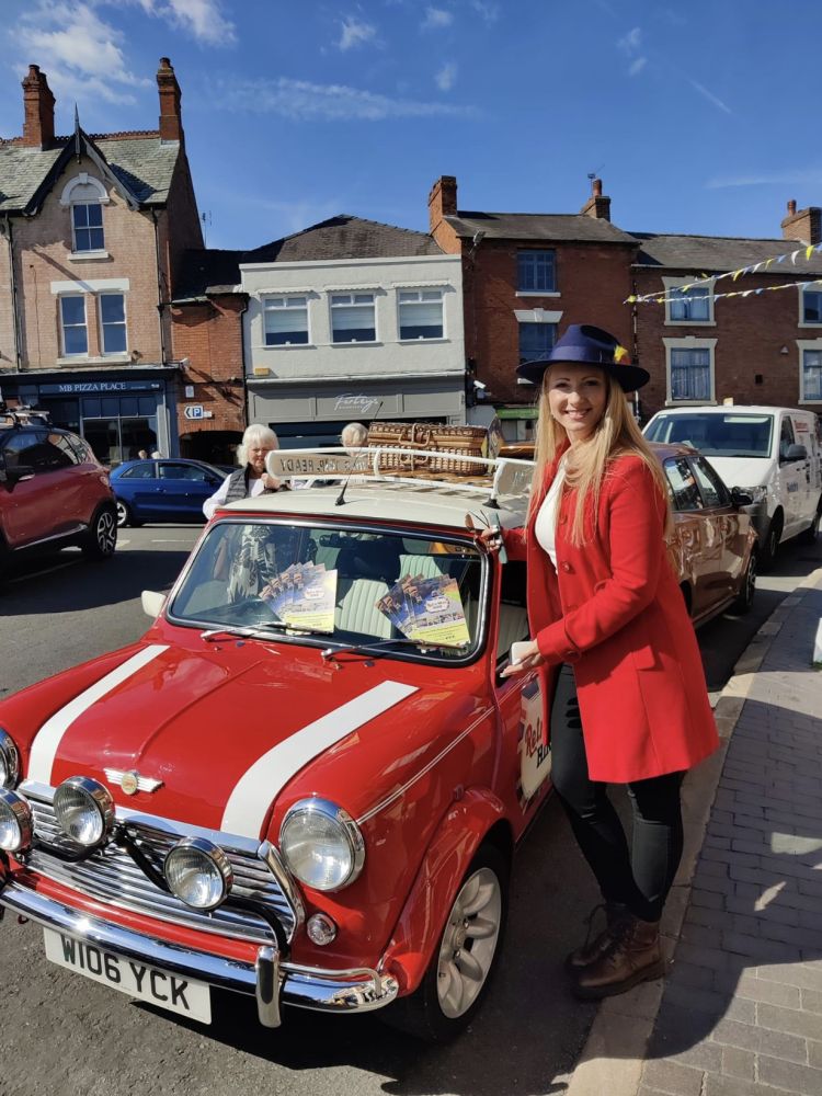 a woman standing next to a classic red mini cooper
