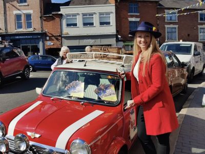 a woman standing next to a classic red mini cooper