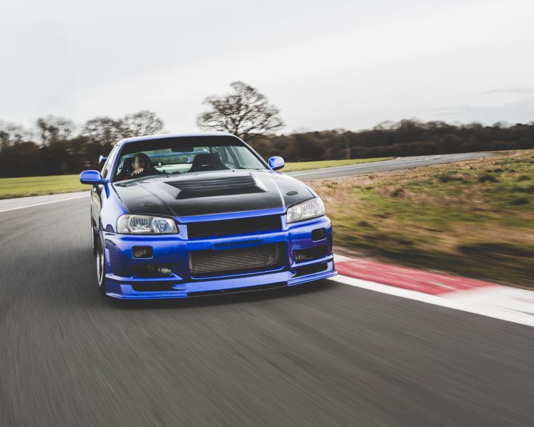 a blue r34 nissan skyline on the track for a drift legends driving experience day