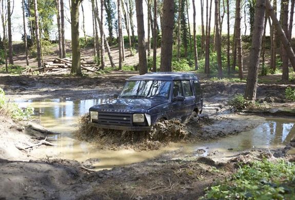 a landrover going through water on a woodland course on an off road driving experience