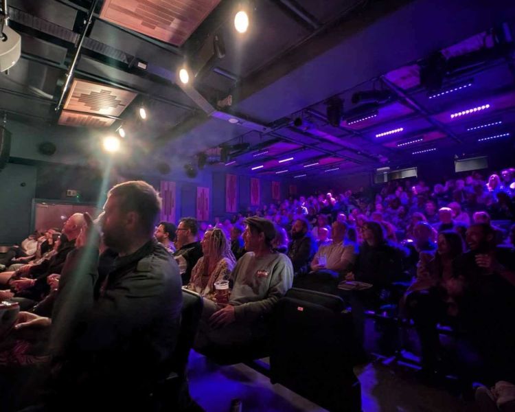 audience watching a comedian on stage at a comedy night