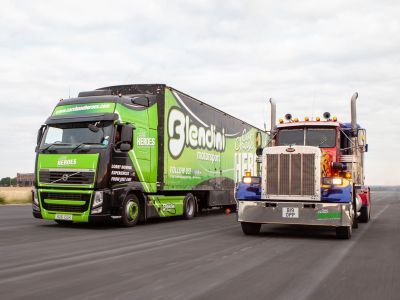 a hgv lorry and an american lorry side by side on a race track as part of a lorry driving experience