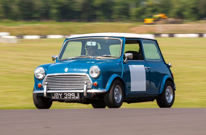 a blue vintage mini cooper on a track as part of a driving experience day