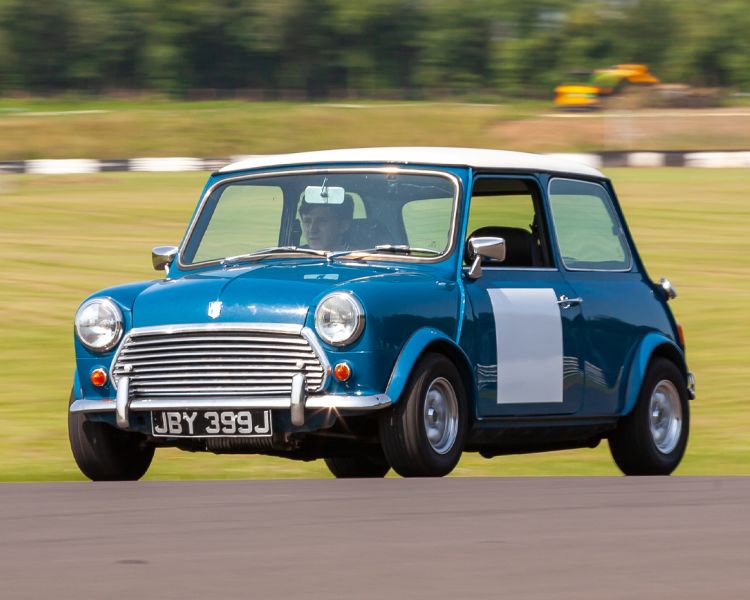 a blue vintage mini cooper on a track as part of a driving experience day
