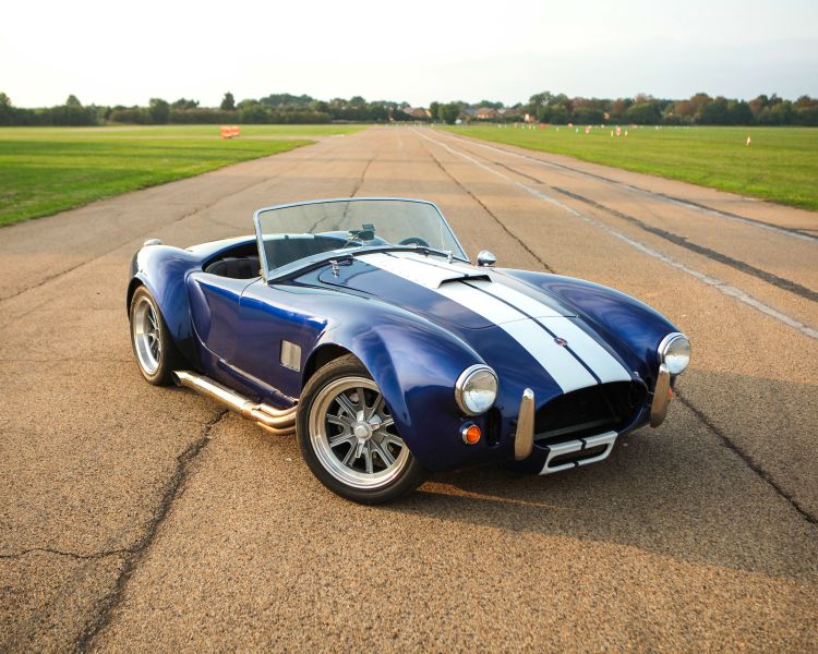 a blue and white vintage sports car on a race track as part of a driving experience day