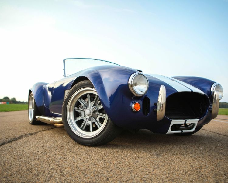 a close up of the front of a vintage sports car on a track as part of a driving experience day