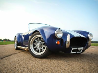 a close up of the front of a vintage sports car on a track as part of a driving experience day