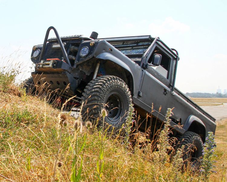 a mad max inspired land rover driving up a hill as part of a driving experience day