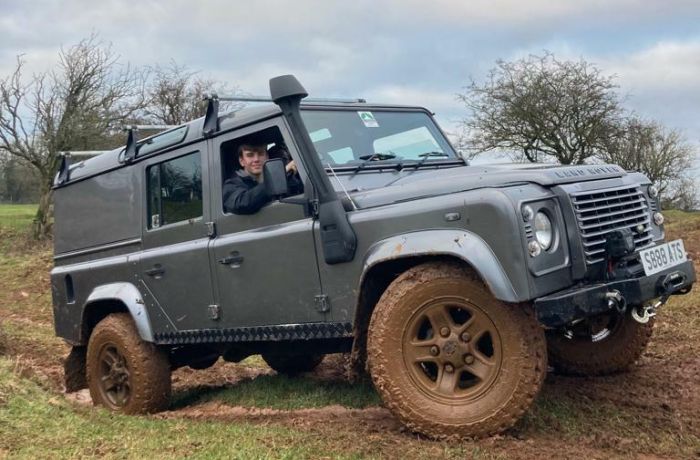 a 4 x 4 land rover driving up a muddy slope as part of an off road driving experience