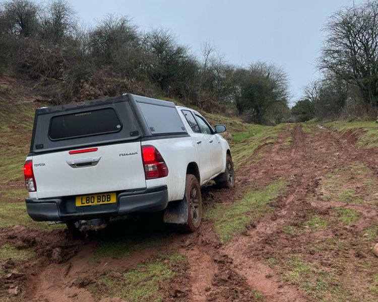 a photo of a white 4 x 4 driving up a dirt track as part of an off road driving experience in Bristol