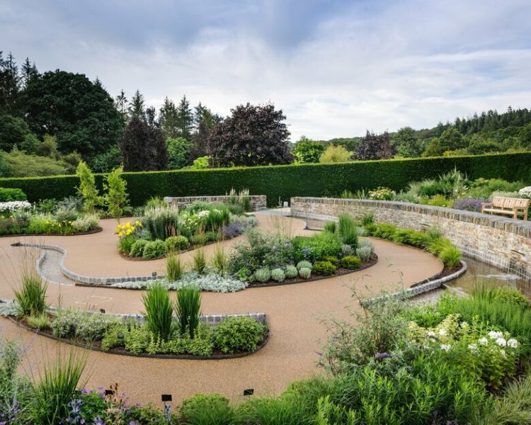 the cool garden at rhs rosemoor in devon with planting separated by gravel paths