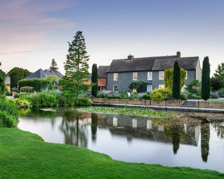a view of upper pond and the farmhouse at rhs hyde hall in essex