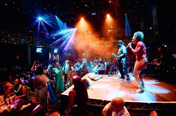 singer and musicians on stage with people dancing at a reggae live music show