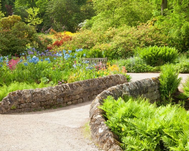 a stone bridge over the stream at rhs harlow carr in north yorkshire