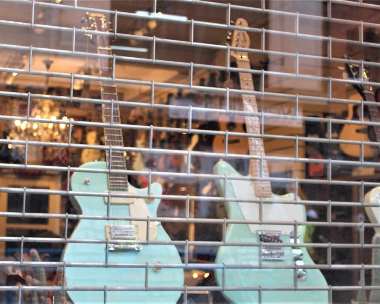 window of a music shop with guitars in the window seen on the david bowie tour in london