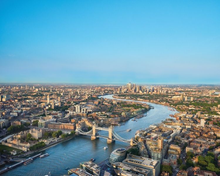 a view over london from the top of the shard looking out over the river thames on a clear sunny day