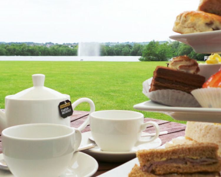afternoon tea set up on a table outside in the gardens of the crown plaza hotel