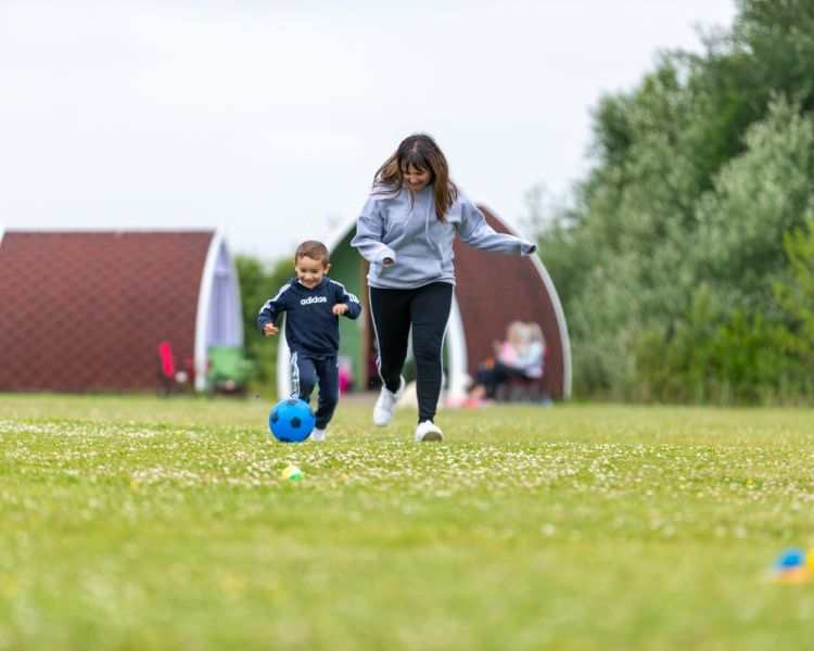 Mum and son kicking a ball