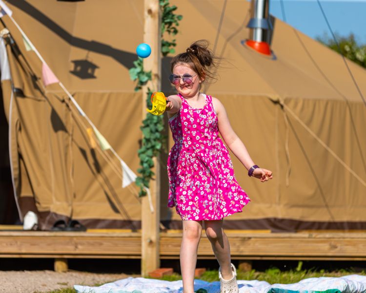 Child outside bell tent